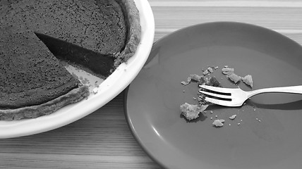 Image showing Plate with crumbs next to a sliced pumpkin pie