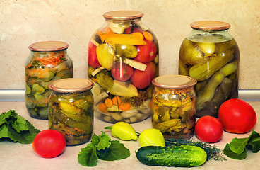 Image showing Canned cucumbers with spices in glass jars.