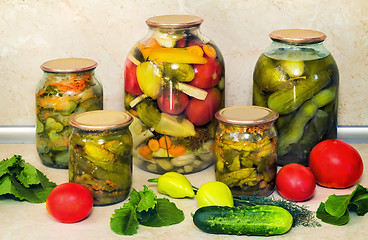 Image showing Canned cucumbers with spices in glass jars.
