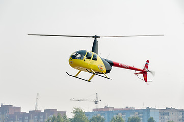 Image showing Pilot of Robinson R44 Raven over city