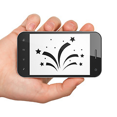 Image showing Holiday concept: Hand Holding Smartphone with Fireworks on display