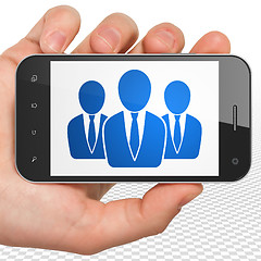 Image showing News concept: Hand Holding Smartphone with Business People on display