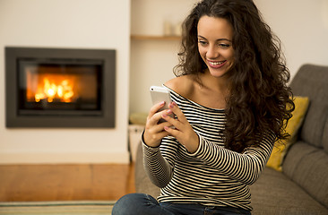 Image showing Woman with her cellphone at home