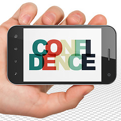 Image showing Finance concept: Hand Holding Smartphone with Confidence on  display