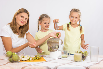 Image showing She and her two daughters squeezed juice in a juicer