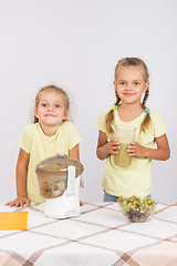 Image showing Two girls squeezed fruit juice in a juicer