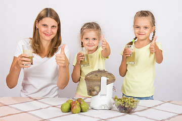Image showing Mother and two daughters show a thumbs up freshly prepared juice