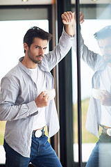 Image showing relaxed young man drink first morning coffee withh rain drops on