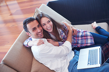 Image showing relaxed young couple working on laptop computer at home