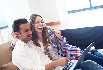 Image showing relaxed young couple working on laptop computer at home