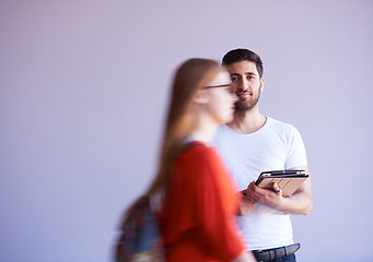 Image showing student working on tablet, people group passing by