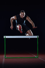 Image showing athlete jumping over a hurdles
