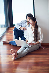 Image showing relaxed young couple working on laptop computer at home