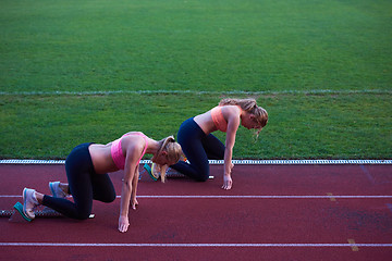 Image showing woman group  running on athletics race track from start