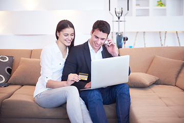 Image showing relaxed young couple working on laptop computer at home