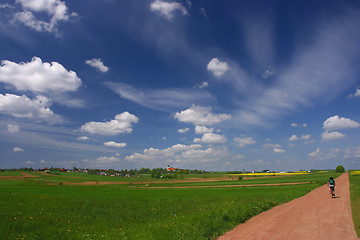 Image showing Blue sky and gravel route with cyklist.