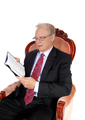 Image showing Mature man in suit reading book.