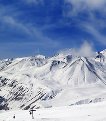 Image showing Winter snowy mountains and ski slope at sun day