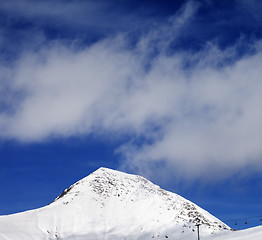 Image showing Chair-lift and ski slope at sun wind day