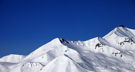 Image showing Panoramic view on snowy winter mountains and clear blue sky in s