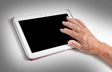 Image showing Hand of senior lady relaxing and reading the screen of her table