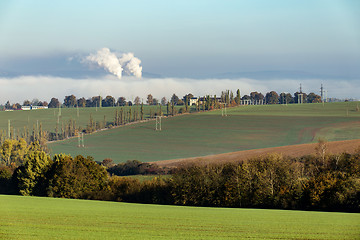 Image showing smoking chimneys in from factory hidden in mist