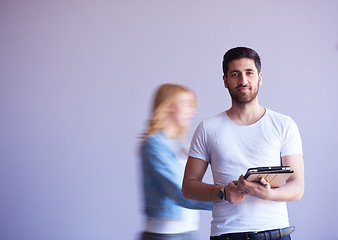 Image showing student working on tablet, people group passing by