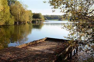 Image showing Wooden jetty in fall looks out over a lake