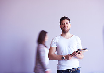 Image showing student working on tablet, people group passing by