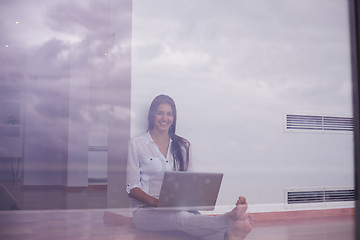 Image showing relaxed young woman at home working on laptop computer