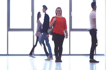 Image showing student girl standing with laptop, people group passing by