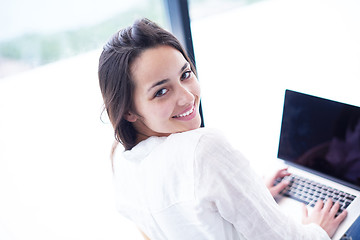 Image showing relaxed young woman at home working on laptop computer