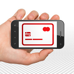 Image showing Business concept: Hand Holding Smartphone with Credit Card on display