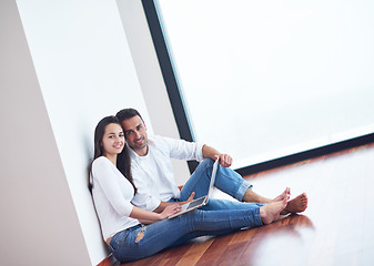 Image showing relaxed young couple working on laptop computer at home