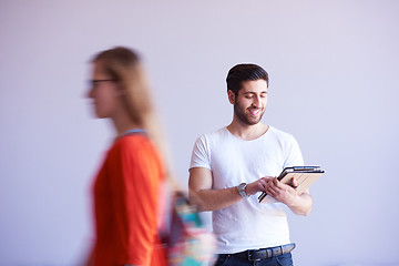 Image showing student working on tablet, people group passing by