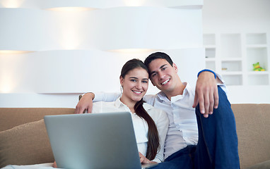 Image showing relaxed young couple working on laptop computer at home