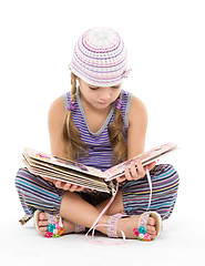 Image showing Little Girl Looking Album Sitting on the Floor