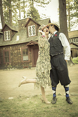 Image showing 1920s Dressed Romantic Couple in Front of Old Cabin
