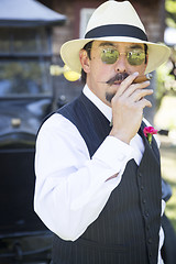 Image showing 1920s Dressed Man Near Vintage Car Smoking Cigar
