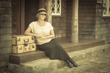 Image showing 1920s Dressed Girl and Suitcases on Porch with Vintage Effect