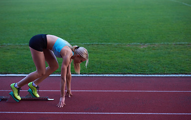 Image showing pixelated design of woman  sprinter leaving starting blocks