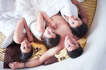 Image showing handsome man in bed with three beautiful woman