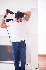 Image showing handsome man using  hairdryer