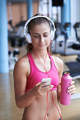 Image showing woman with headphones in fitness gym