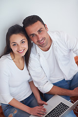 Image showing relaxed young couple working on laptop computer at home