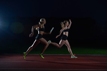 Image showing athletic runners passing baton in relay race