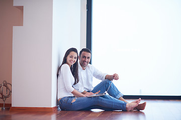 Image showing relaxed young couple working on laptop computer at home