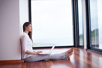 Image showing relaxed young woman at home working on laptop computer