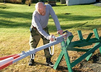 Image showing Man painting a tow bar