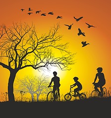 Image showing Family cycling in the countryside at sunset